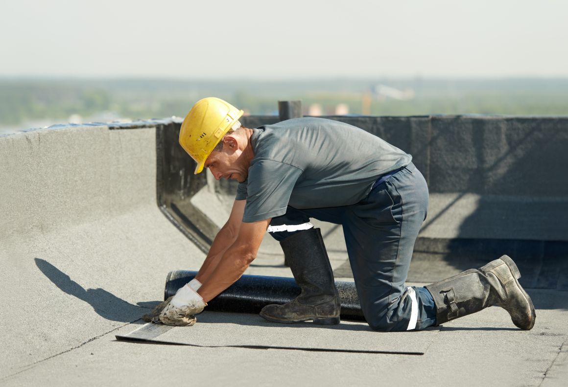 Handwerker dichten eine Gefälledämmung ab