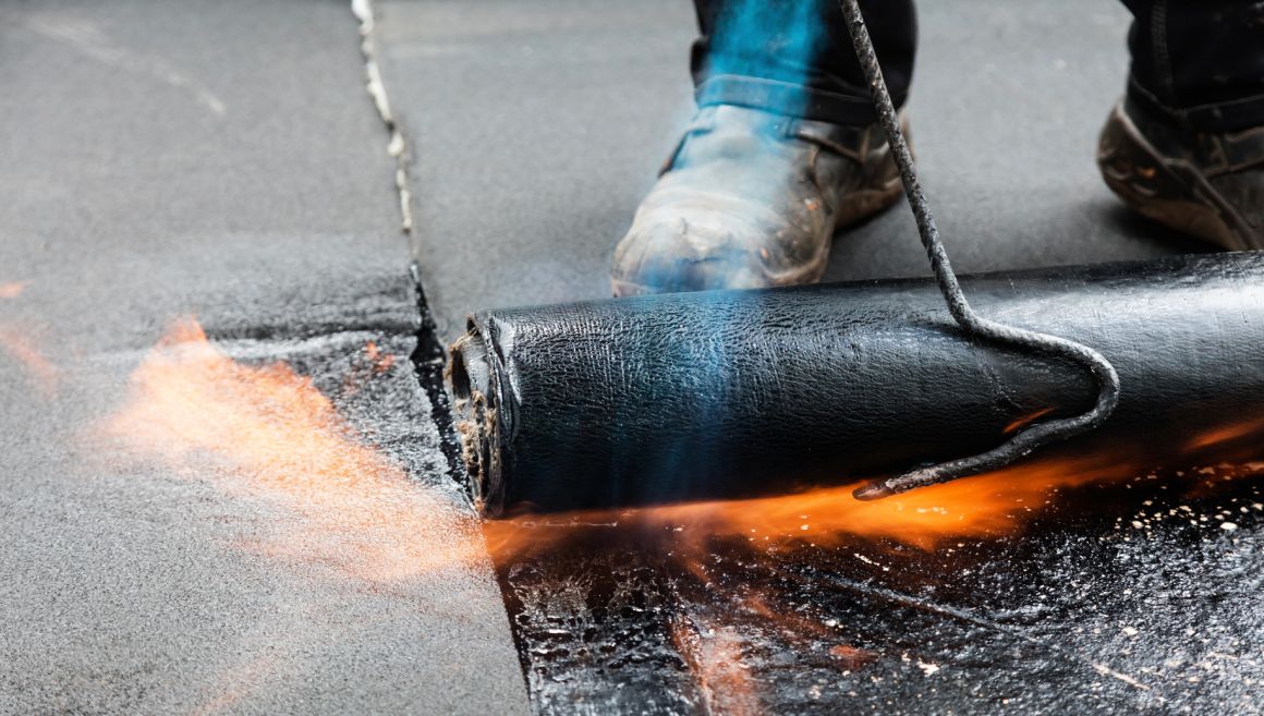 Dachdecker bei der Flachdachabdichtung mit Bitumen