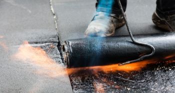 Dachdecker bei der Flachdachabdichtung mit Bitumen