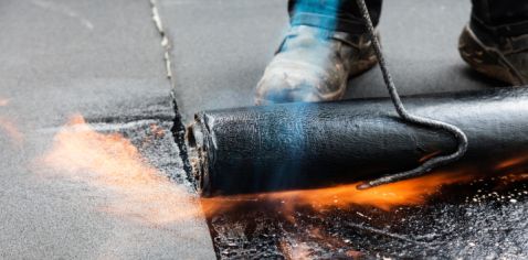 Dachdecker bei der Flachdachabdichtung mit Bitumen